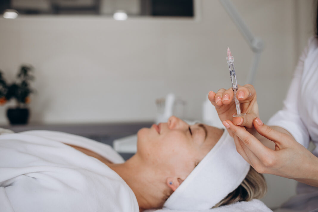 Woman lays in medspa with beautician doctor with peptide therapy injection